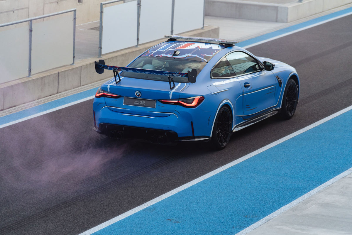 BMW M4 race car with rear wing on track