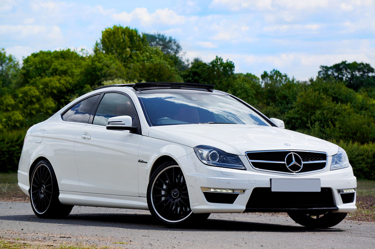 White Mercedes-AMG C63 coupe on the road